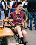 Frau trägt HangOwear DILARA T-Shirt weinrot mit goldenem Herz-Madl-Druck auf der Bierbank