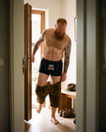 ZAPFHAHN Herren-Wäsche Schwarz am Model beim Anziehen im Flur – Hangowear